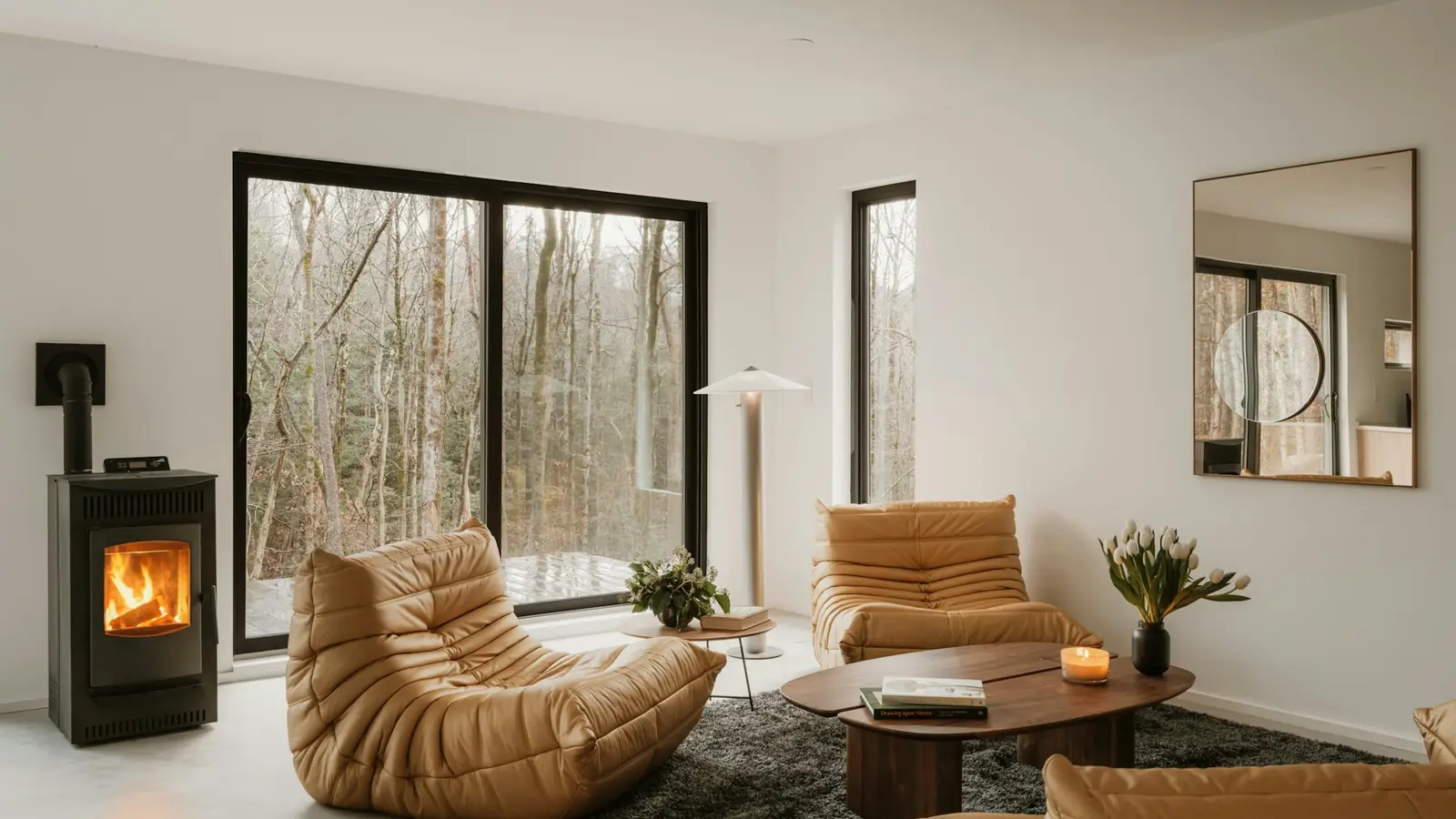 Poêle noir vitré allumé dans un salon moderne ouvert sur la forêt